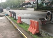 Personel Polsek Biringkanaya Bersihkan Endapan Pasir di Jalan Raya