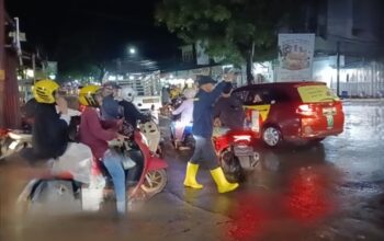Bhabinkamtibmas Polsek Rappocini Per­lancar Arus Lalu Lintas Saat Hujan Guyur Makassar